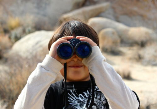 Ein Junge schaut durch ein Fernglas.
