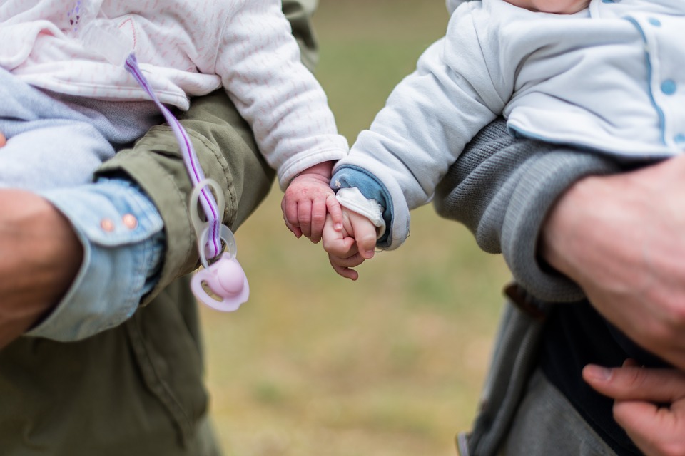 Eltern mit ihren Kleinkindern auf dem Arm.