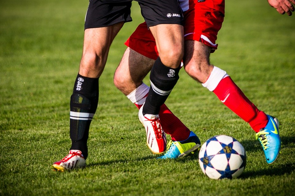 Zwei Fußballer kämpfen um den Ball.